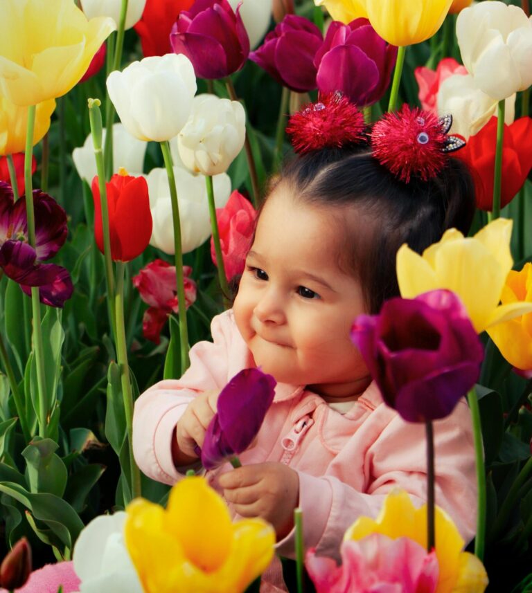 baby smiling in tulip field after visiting children's dentist in Saugus, MA